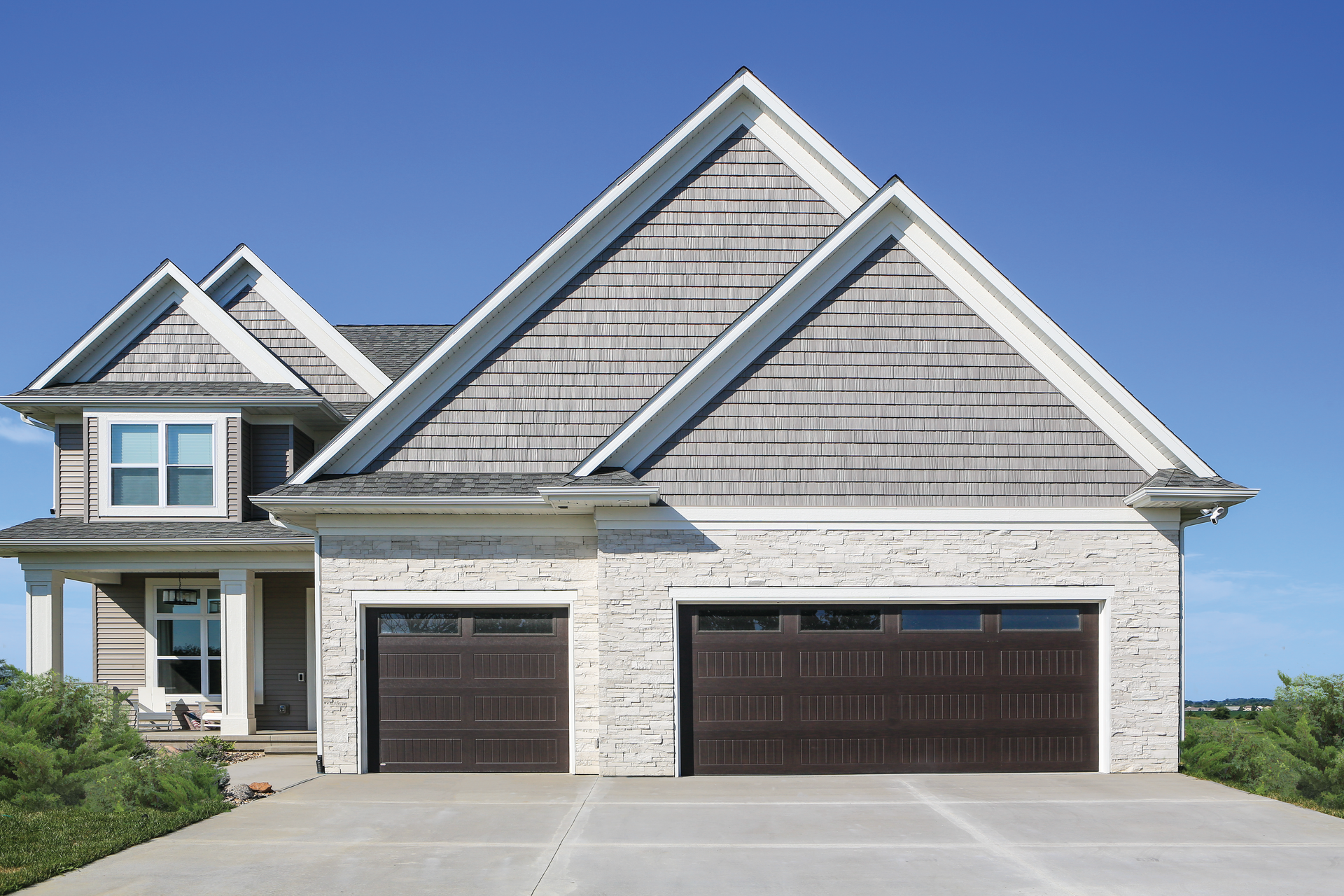 A large house with two garage doors and a driveway