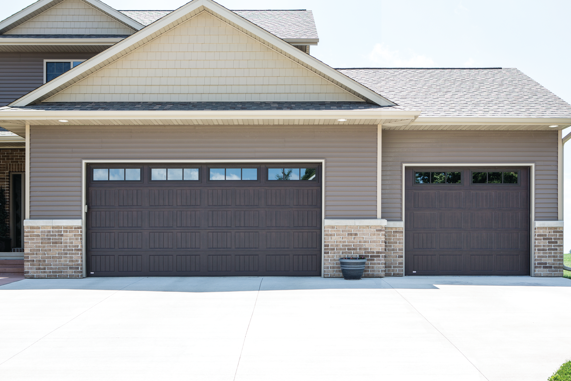 A large house with two garage doors and a large driveway.