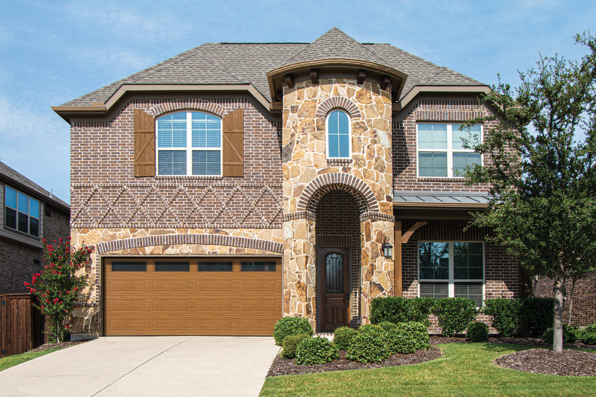 A large brick house with a wooden garage door.