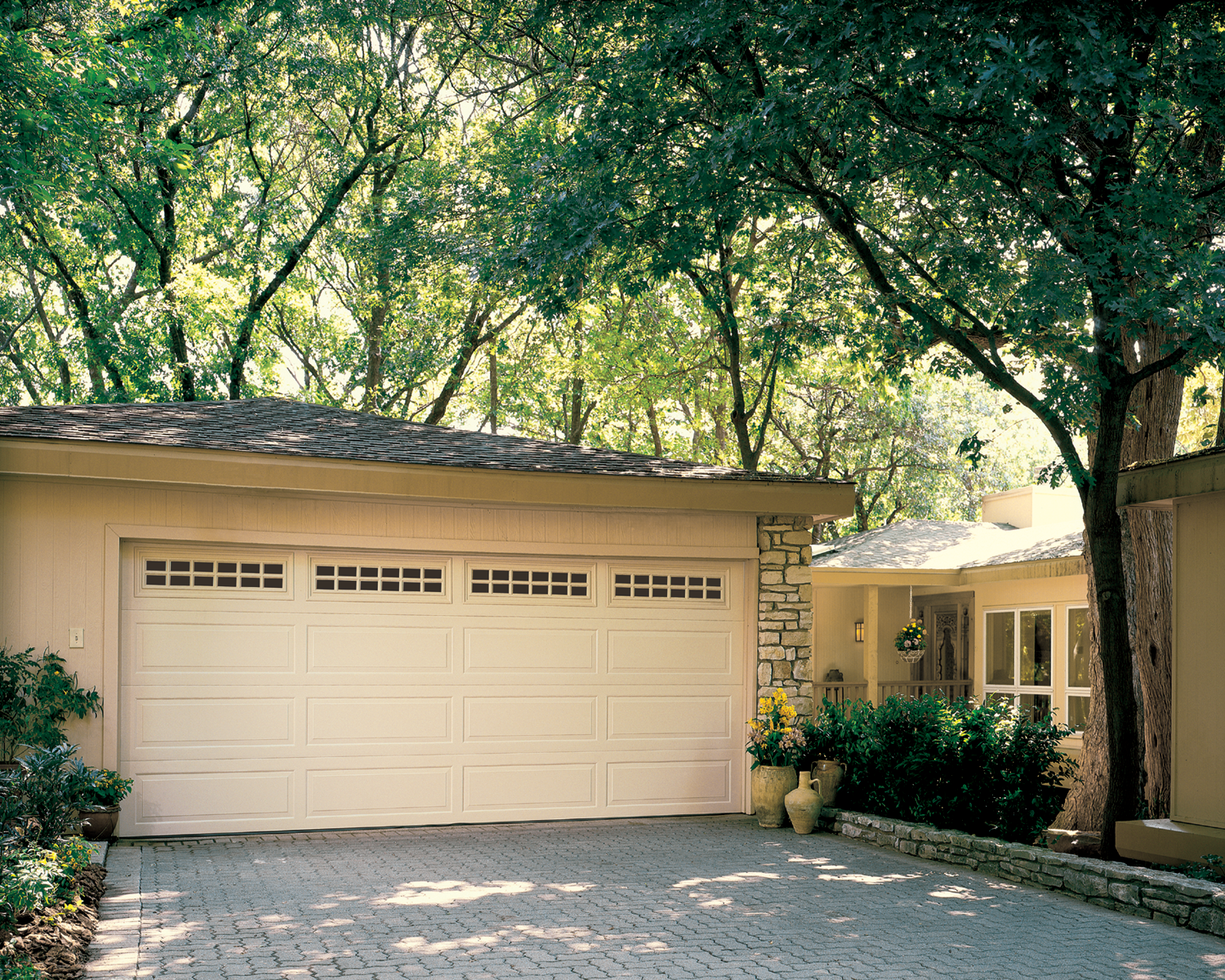 A white garage door is sitting in front of a house