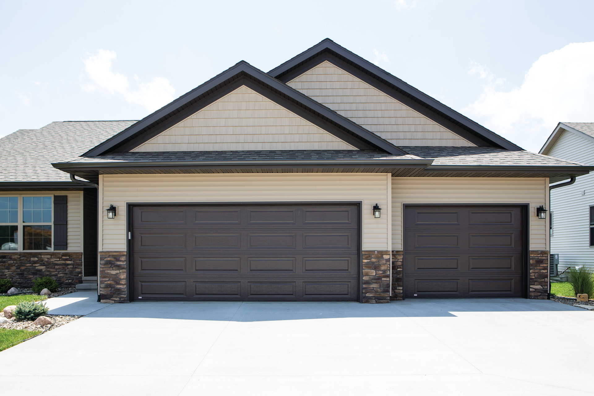 A large house with two garage doors and a driveway.