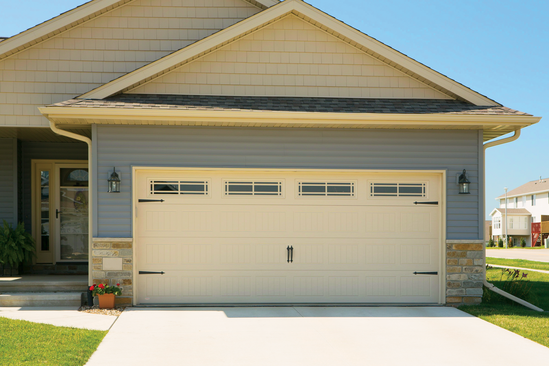 A house with a large garage door and a concrete driveway.