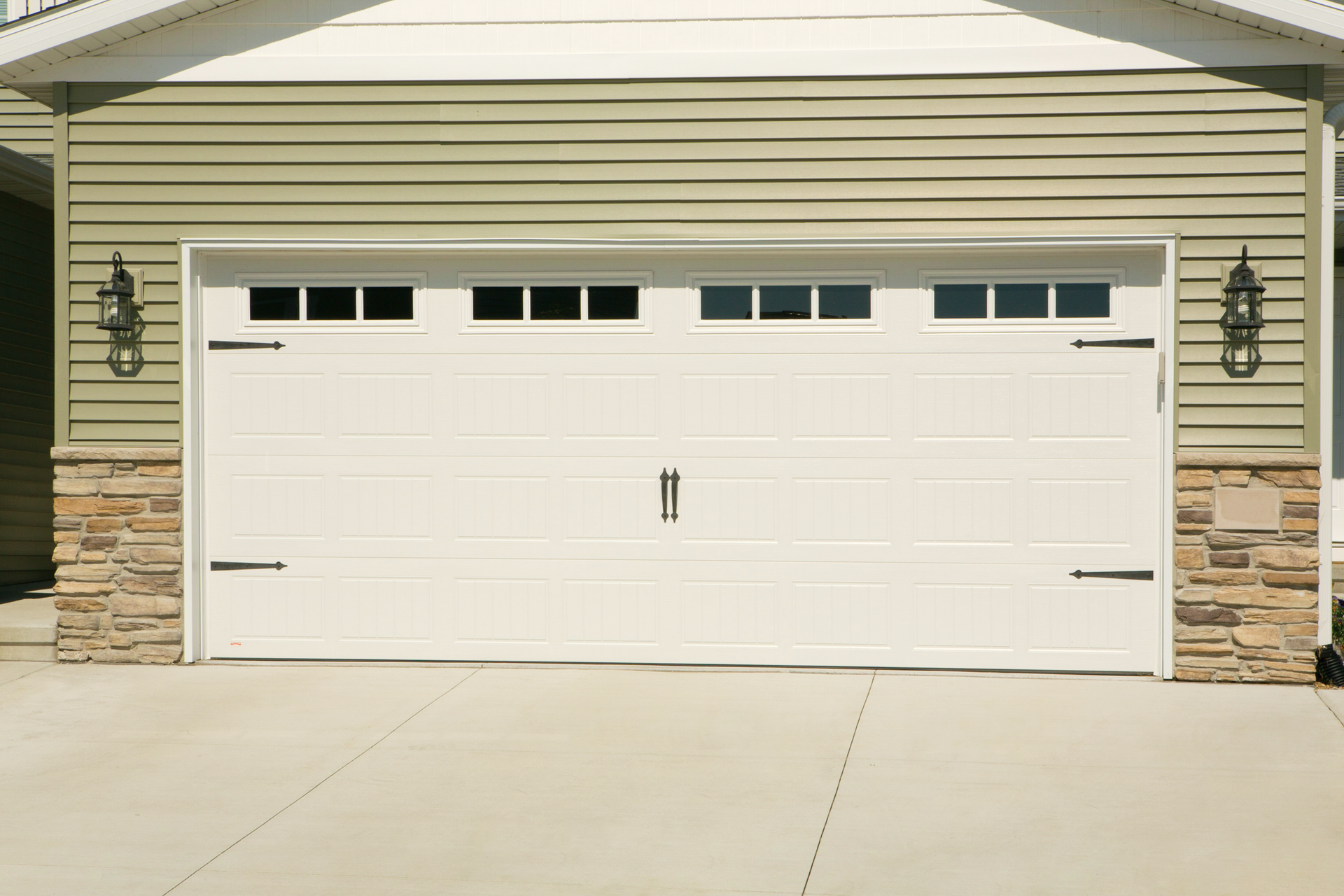 A white garage door is sitting in front of a house