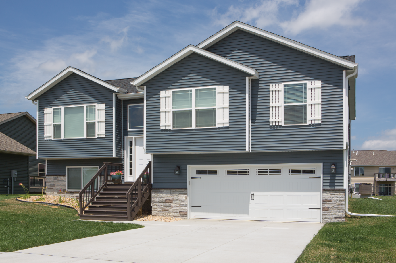 A large house with a garage and stairs in front of it