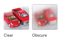 Two red toy cars are sitting next to each other on a white surface.