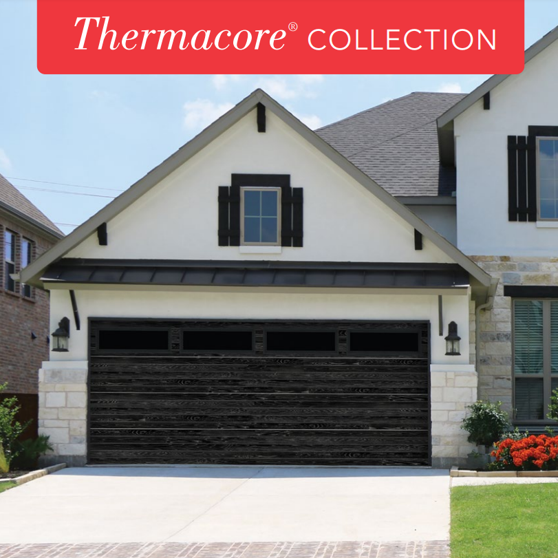 A white house with a black garage door and a black roof.