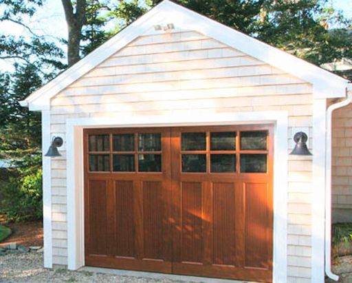 A garage with a wooden door and white siding
