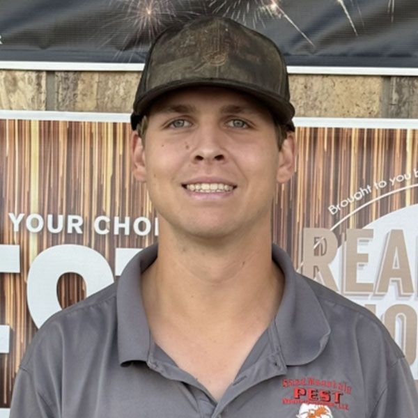 Man in camouflage cap and grey shirt smiles; 