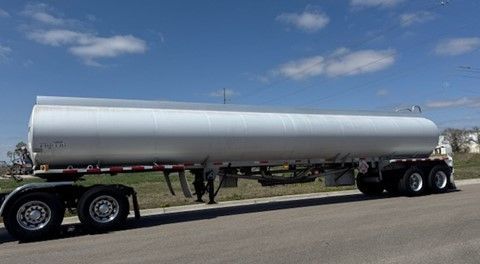 A large white tanker truck is parked on the side of the road.