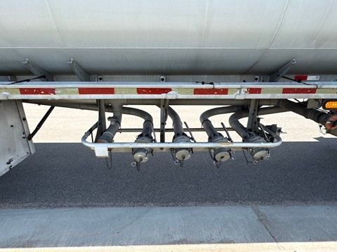 The back of a truck with a bunch of pipes attached to it.