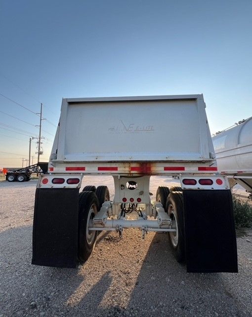 A white dump truck is parked on the side of the road