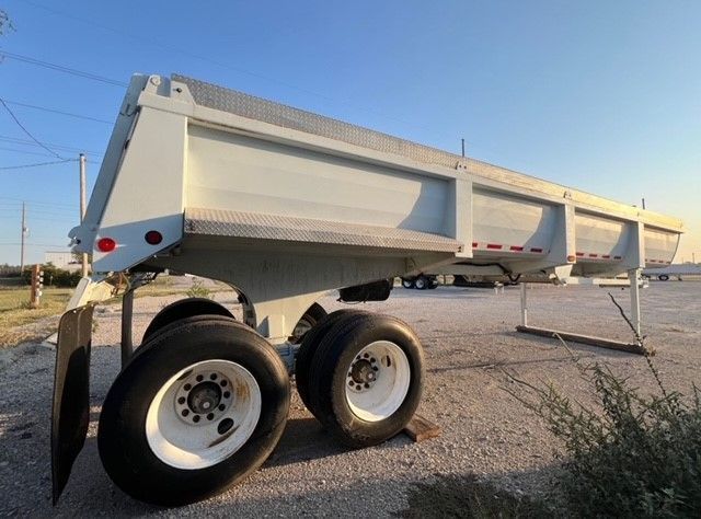 A white dump truck is parked in a parking lot.