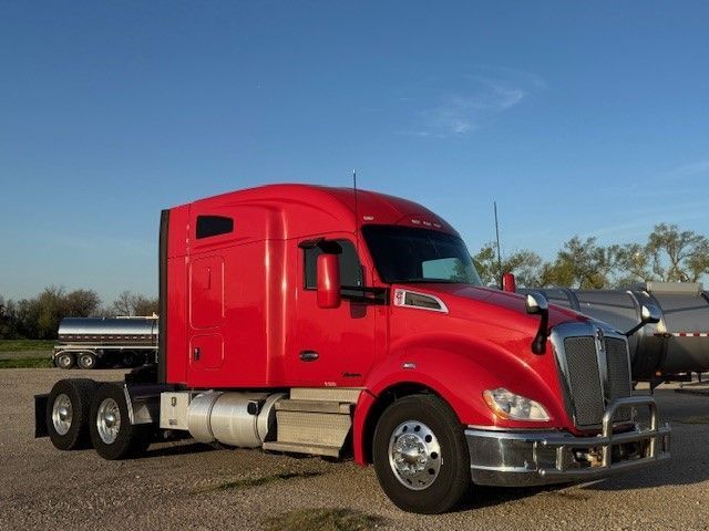 A red semi truck is parked in a parking lot