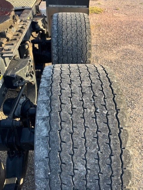 A close up of a truck 's tires on a dirt road