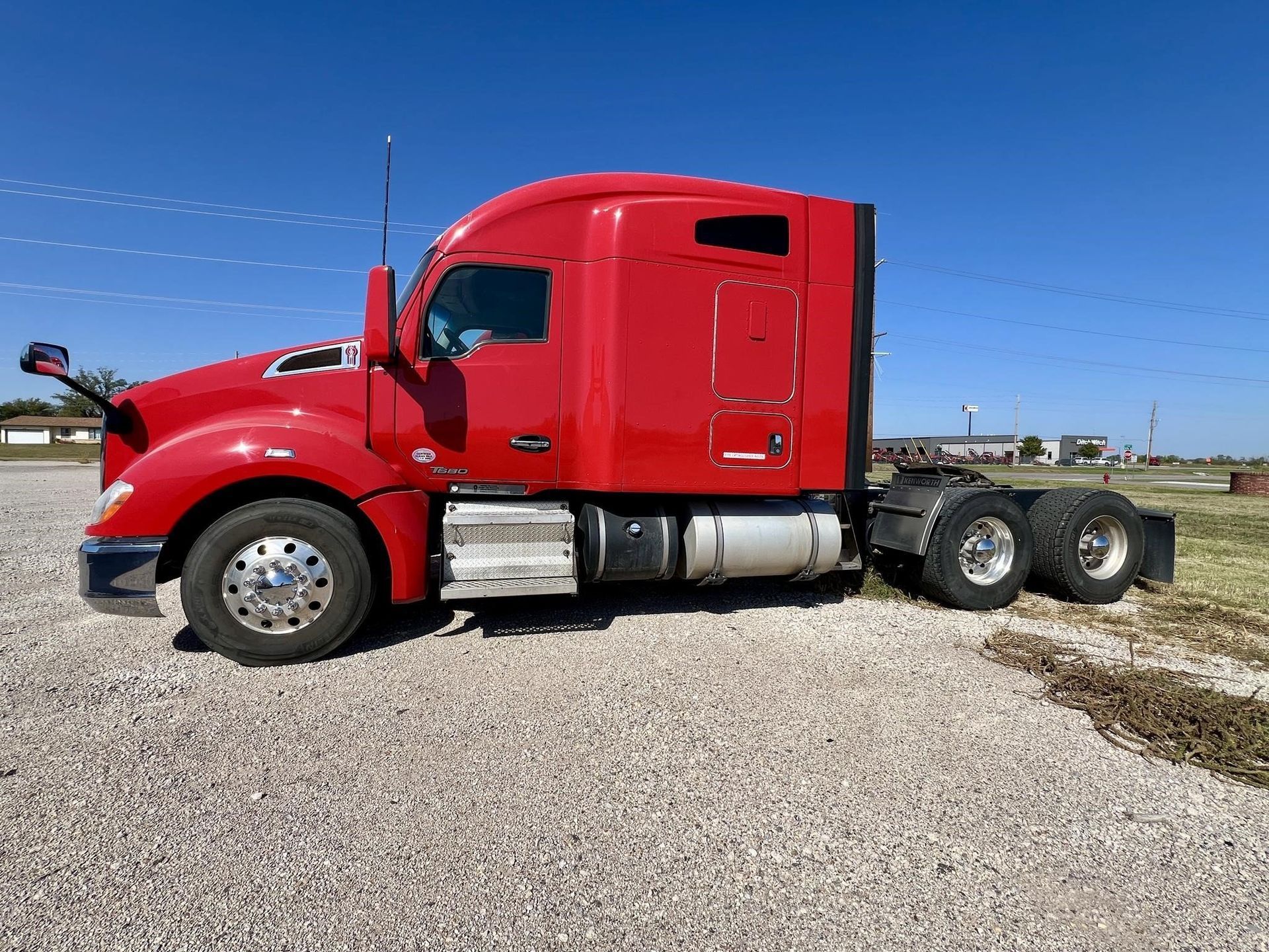 A red semi truck is parked in a parking lot