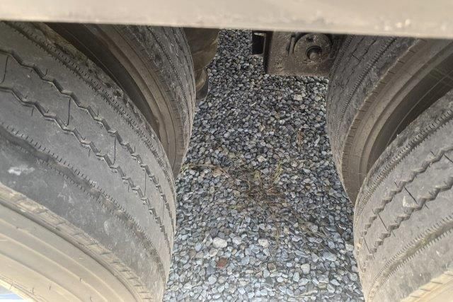 A close up of a tire on a gravel road.