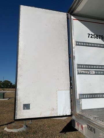 A white truck with the door open is parked in a field.