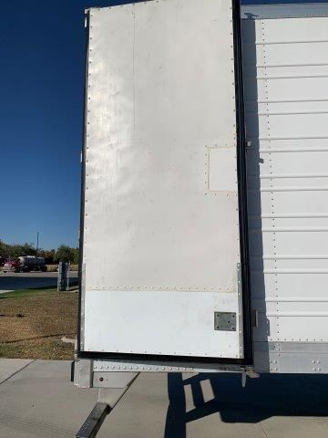 A white truck with the door open is parked on the side of the road.