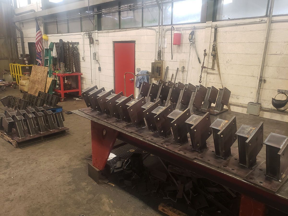 Metal components rest on a factory table.