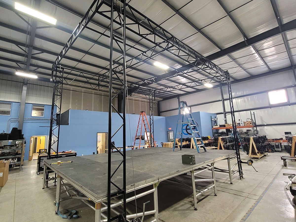 A large warehouse with a stage in the middle of it.