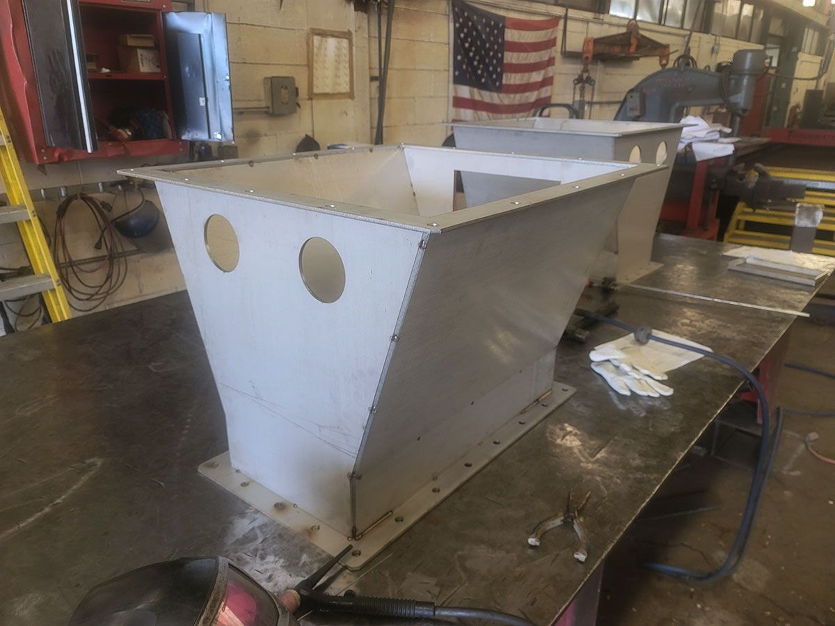 A piece of metal is sitting on top of a metal table.