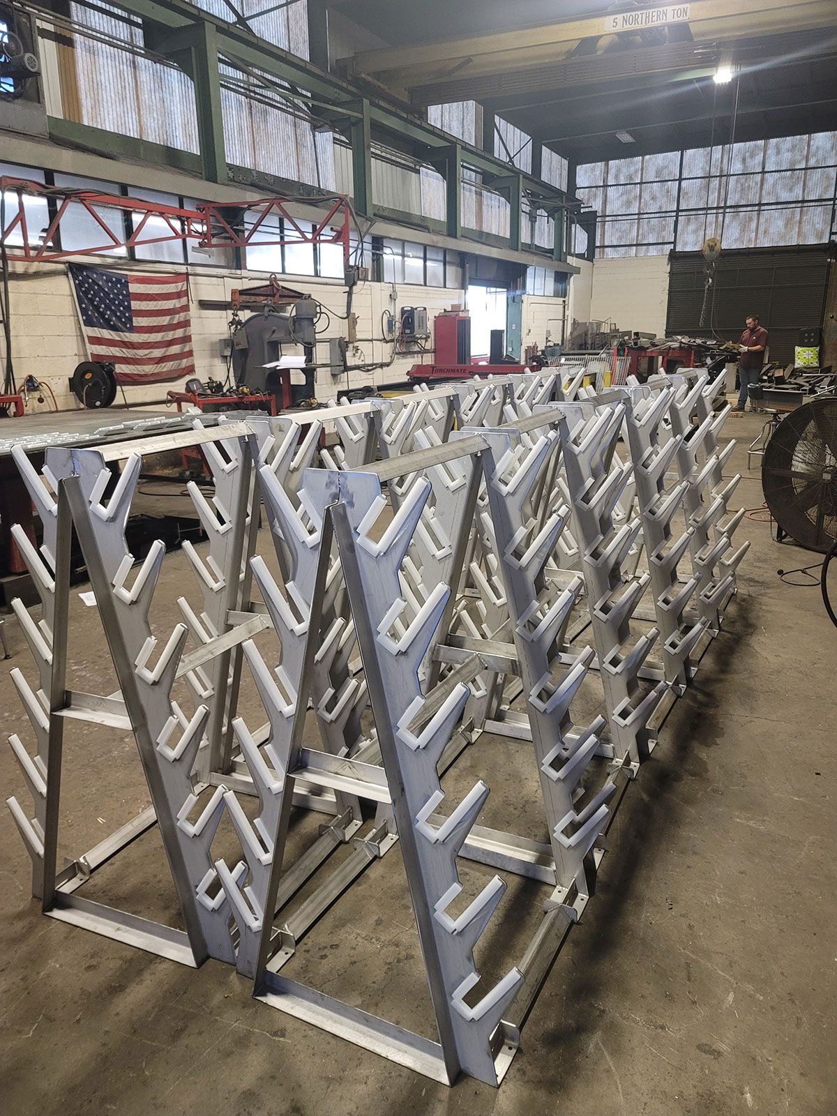 A large metal structure is being built in a factory.