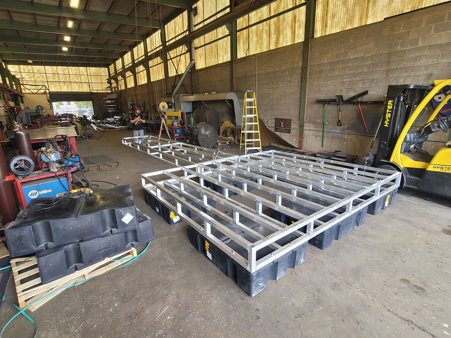 A forklift is parked in a warehouse next to a large metal structure.