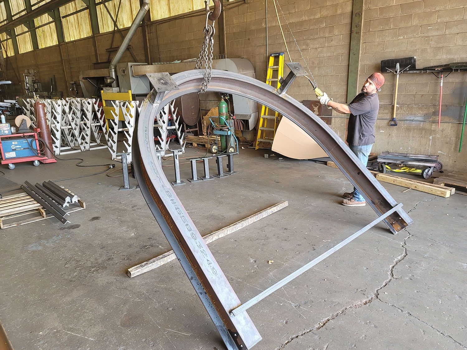 A man is working on a large piece of metal in a factory.