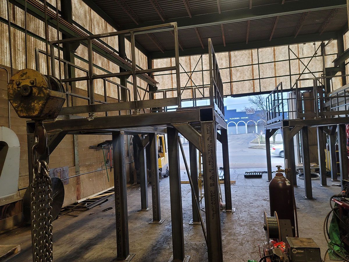 A large metal structure is being built in a warehouse.