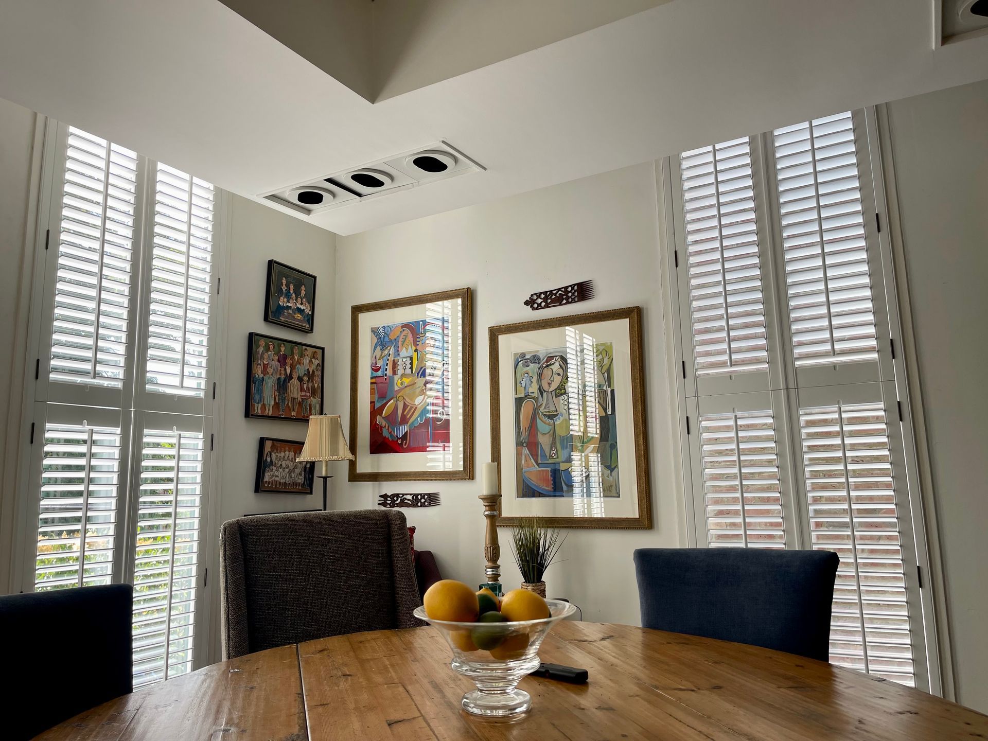 A dining room table with a bowl of fruit on it