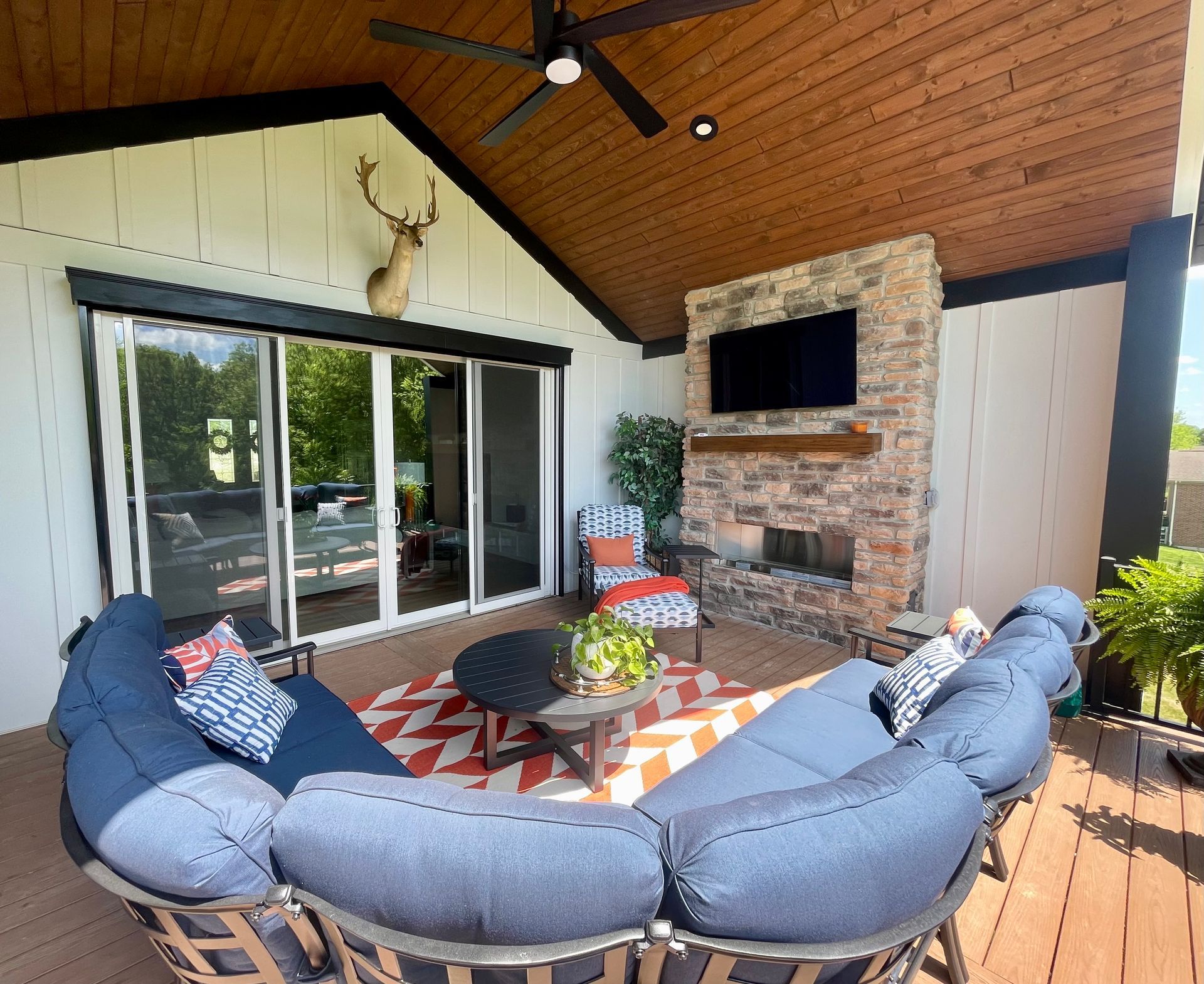 A patio with a couch and chairs and a fireplace