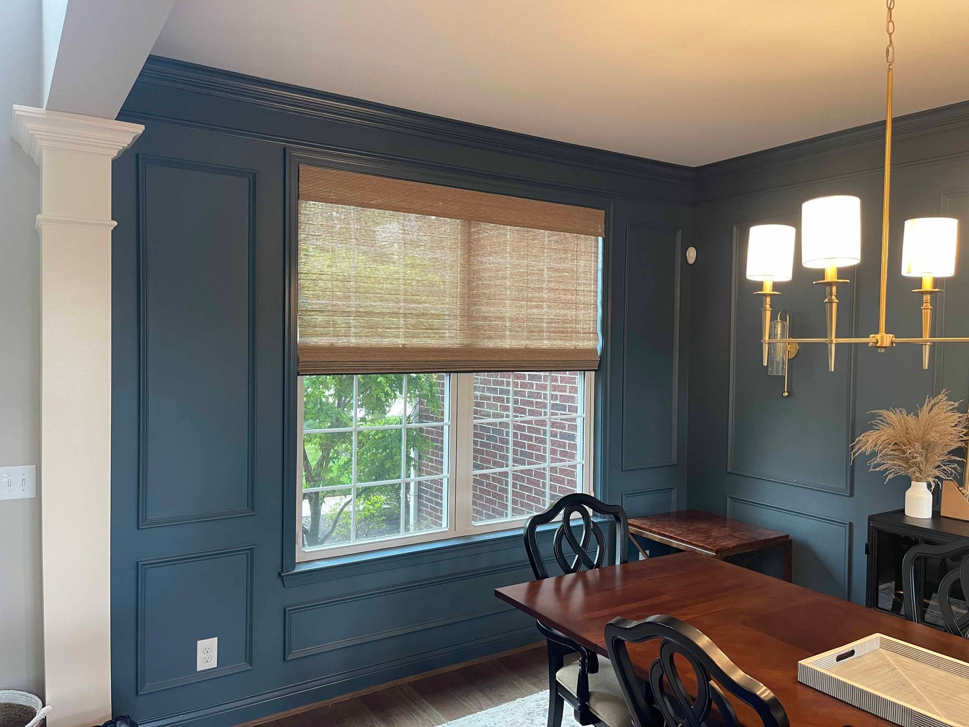 A dining room with a table and chairs and a large window.
