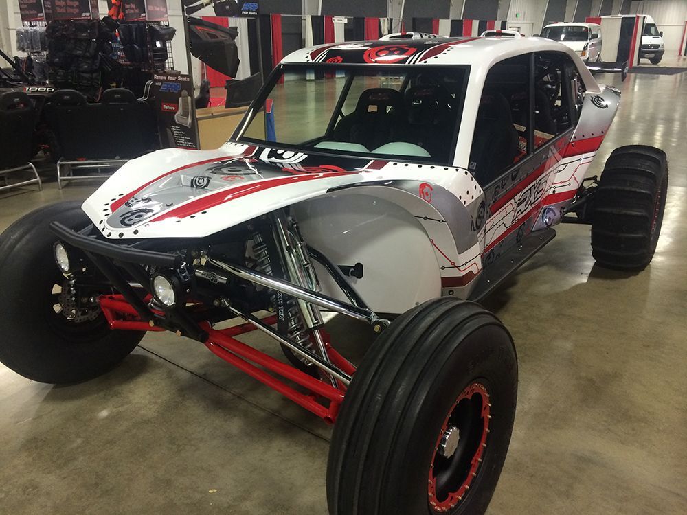A white and red buggy is parked on a concrete floor.