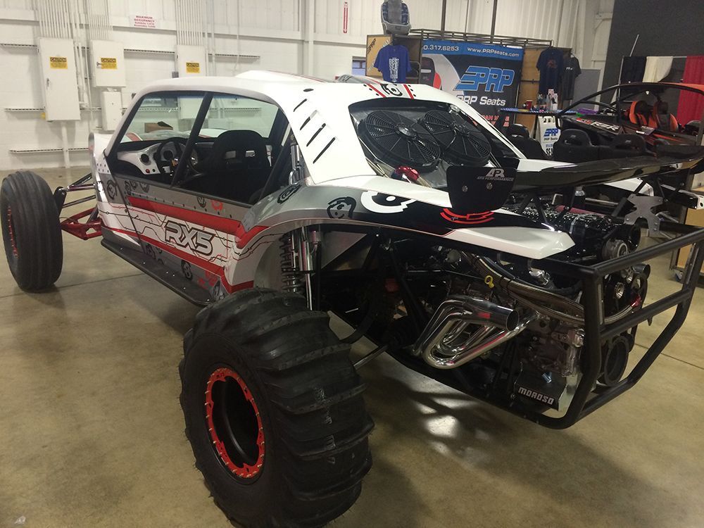 A white and red buggy is parked in a garage.