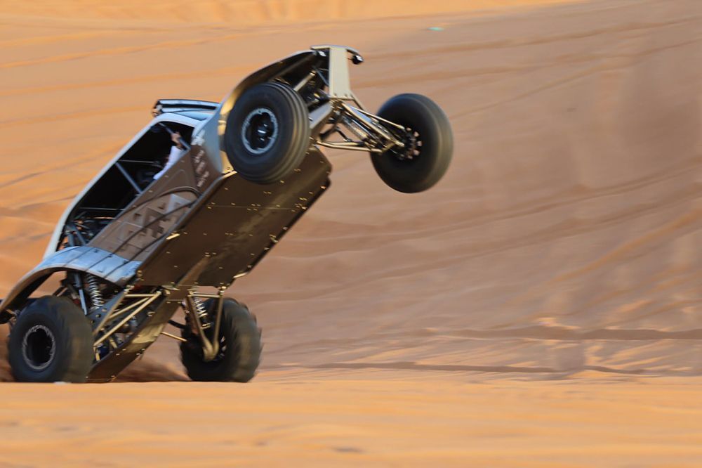 A buggy is doing a trick in the desert ..