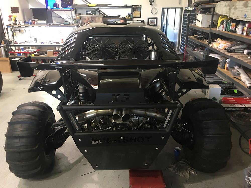A black buggy is sitting in a garage.