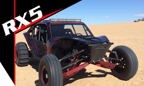 A rx5 buggy is parked in the sand.