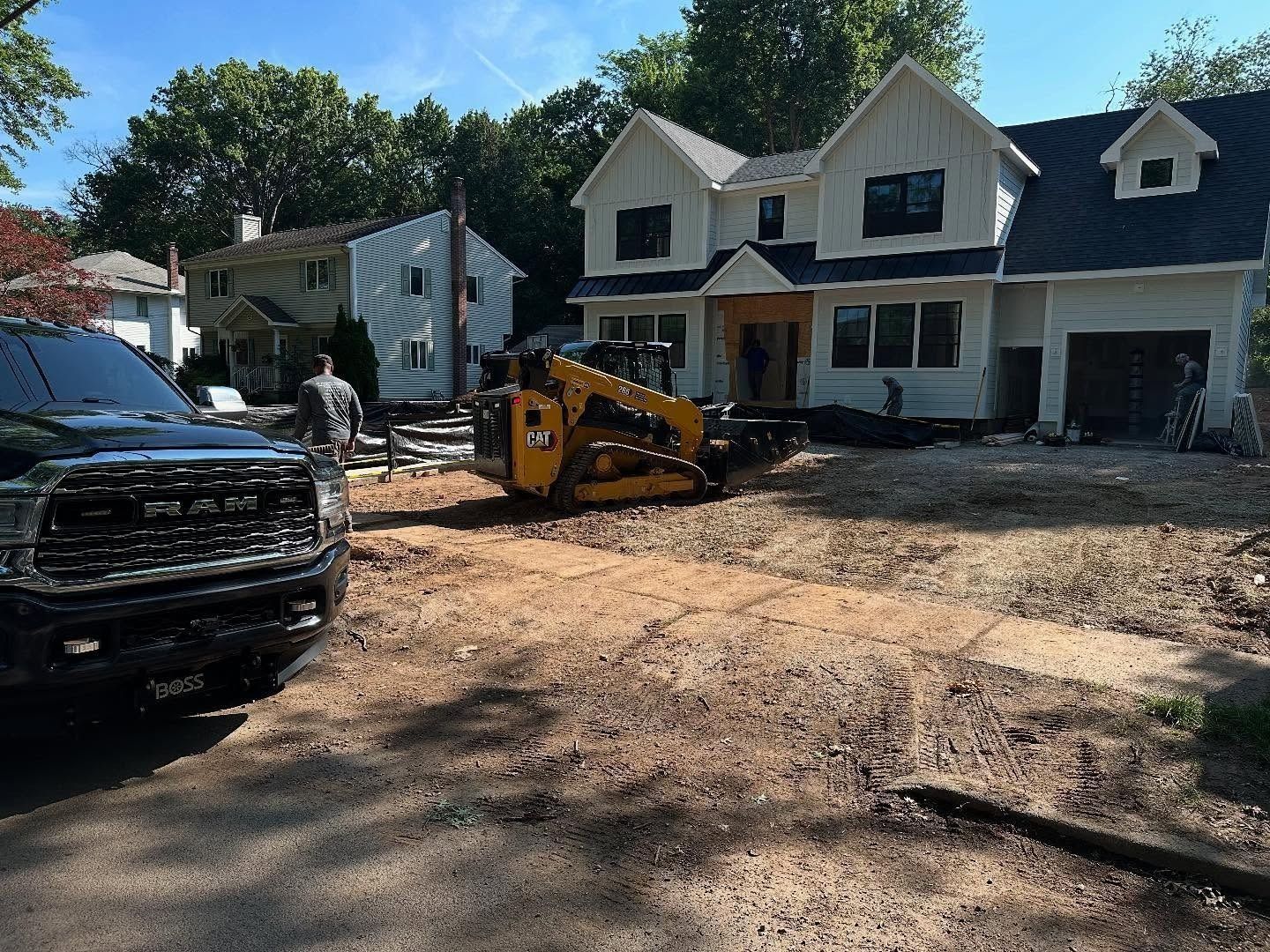 Construction site: House with heavy equipment and a truck in front.
