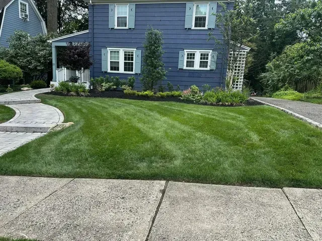 Blue two-story house with white trim and a manicured green lawn in front