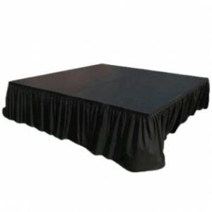 Black square table with draped black skirting on a white background
