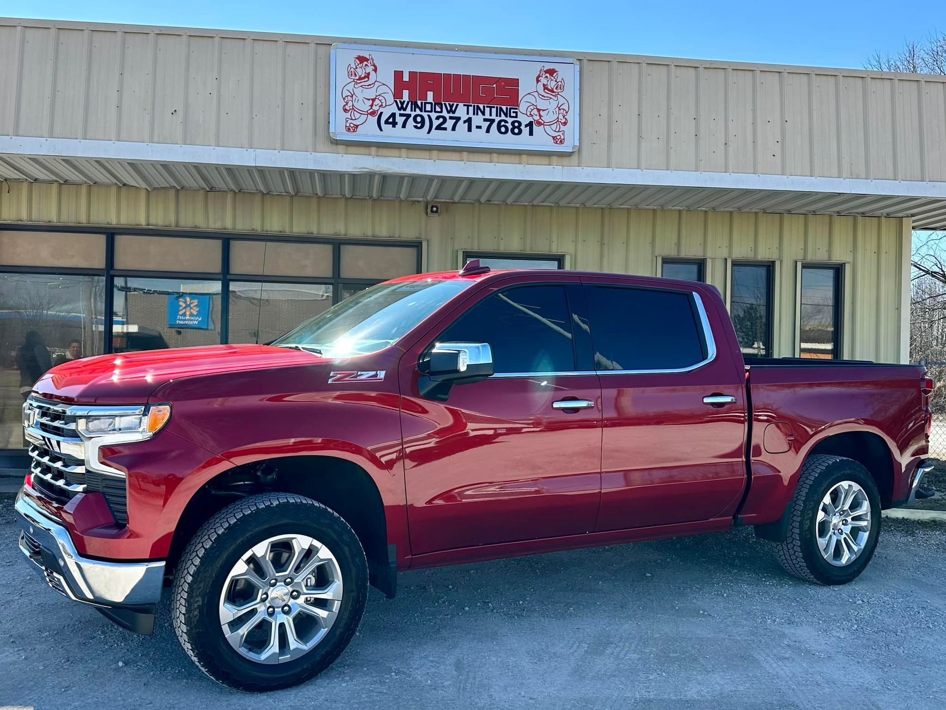 Red Chevrolet Silverado truck parked in front of a building.