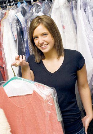 woman holding a dry cleaned shirt