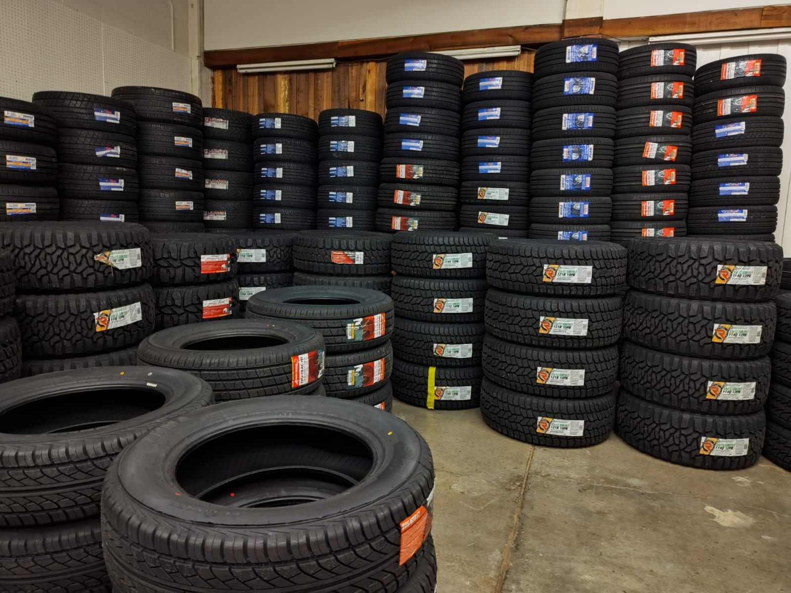A warehouse filled with lots of tires stacked on top of each other.