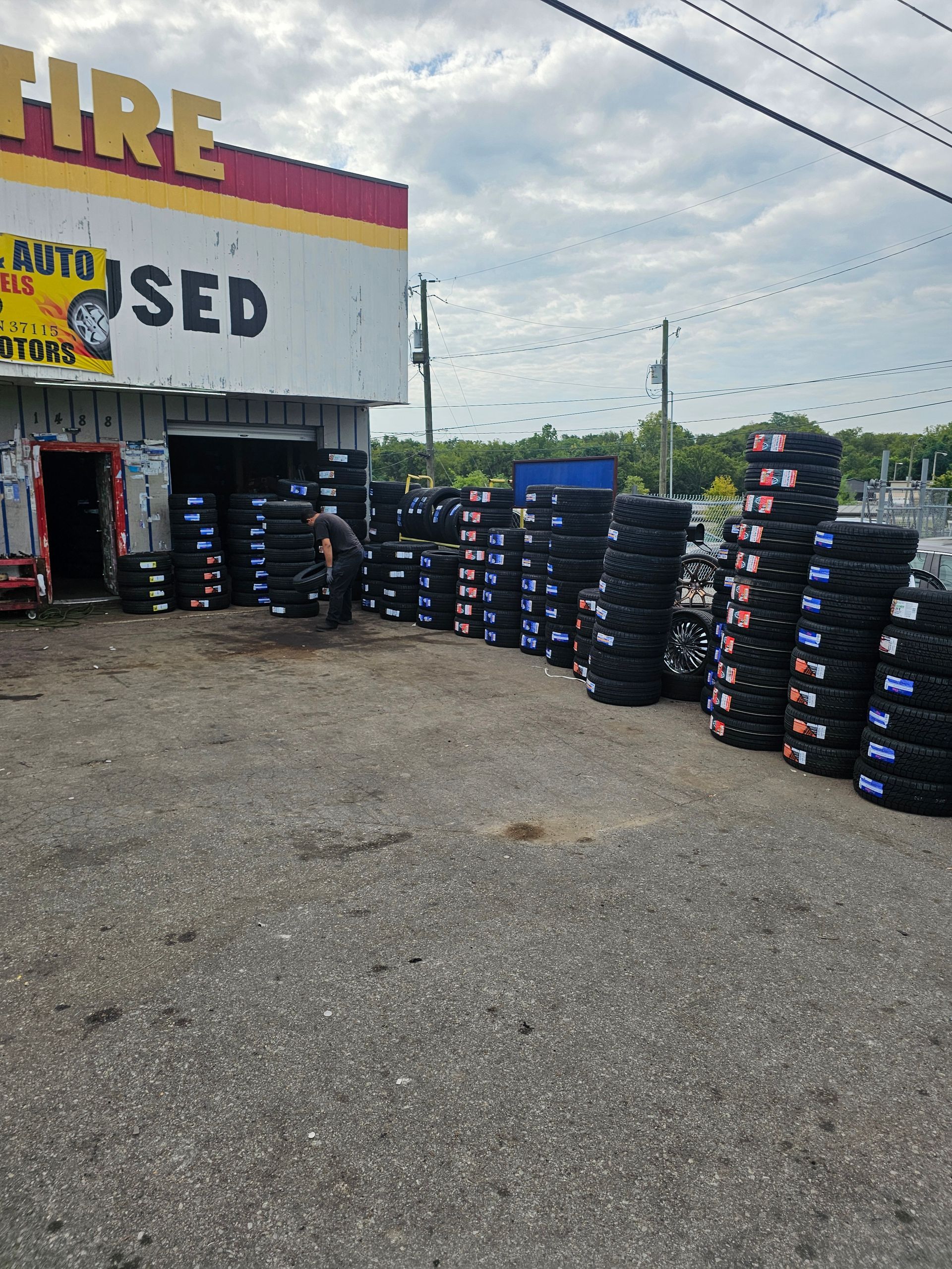 A stack of used tires outside of a tire store