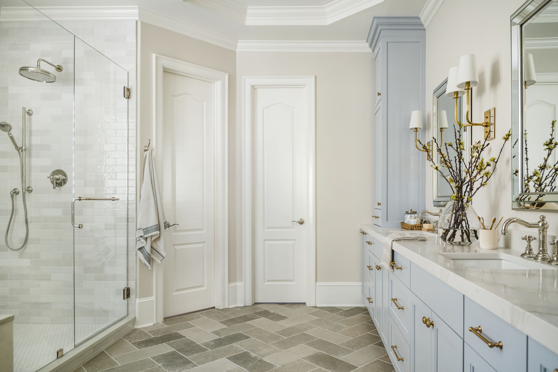 A bathroom with two sinks , a shower , and a mirror.
