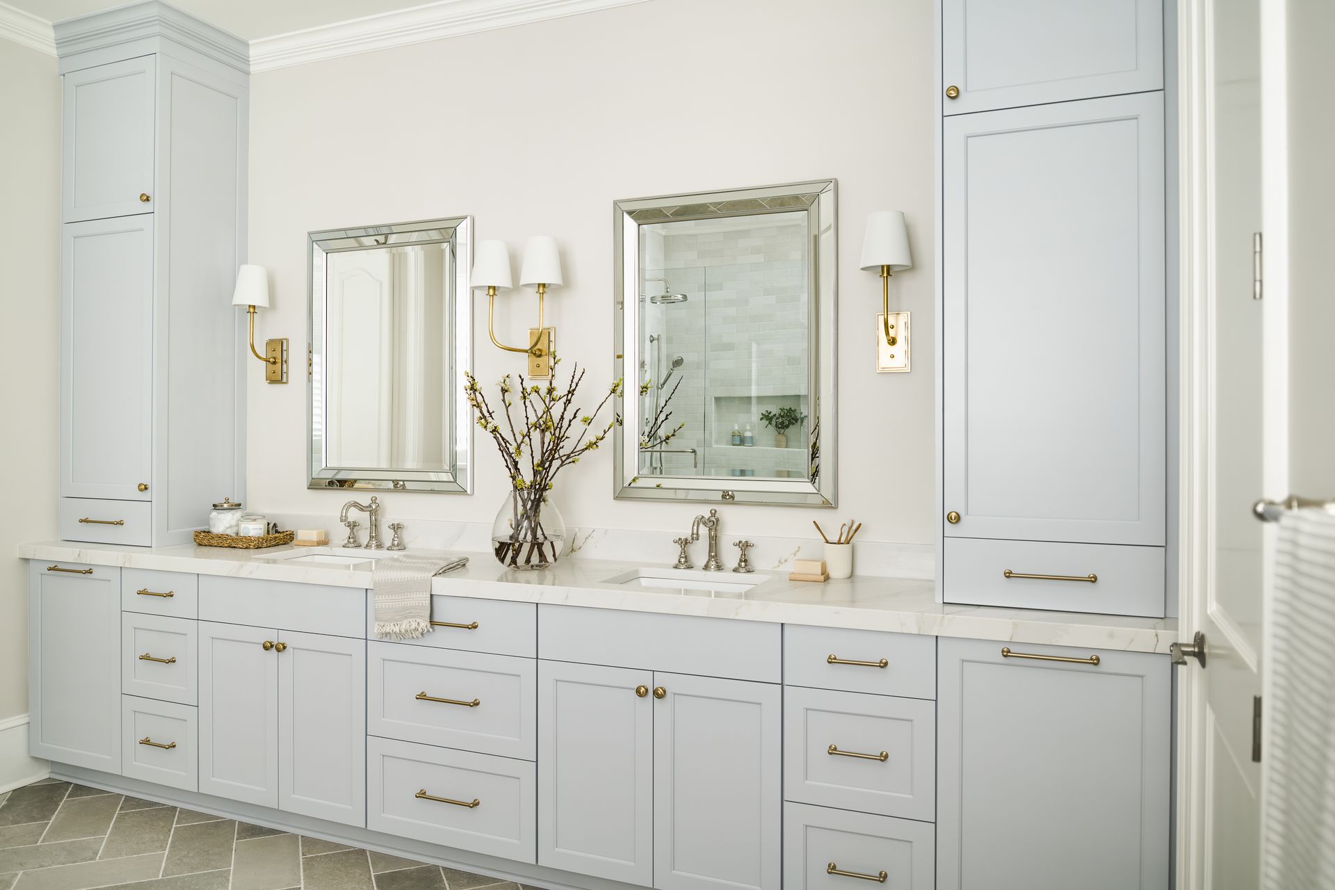 A bathroom with two sinks , two mirrors , and lots of cabinets.