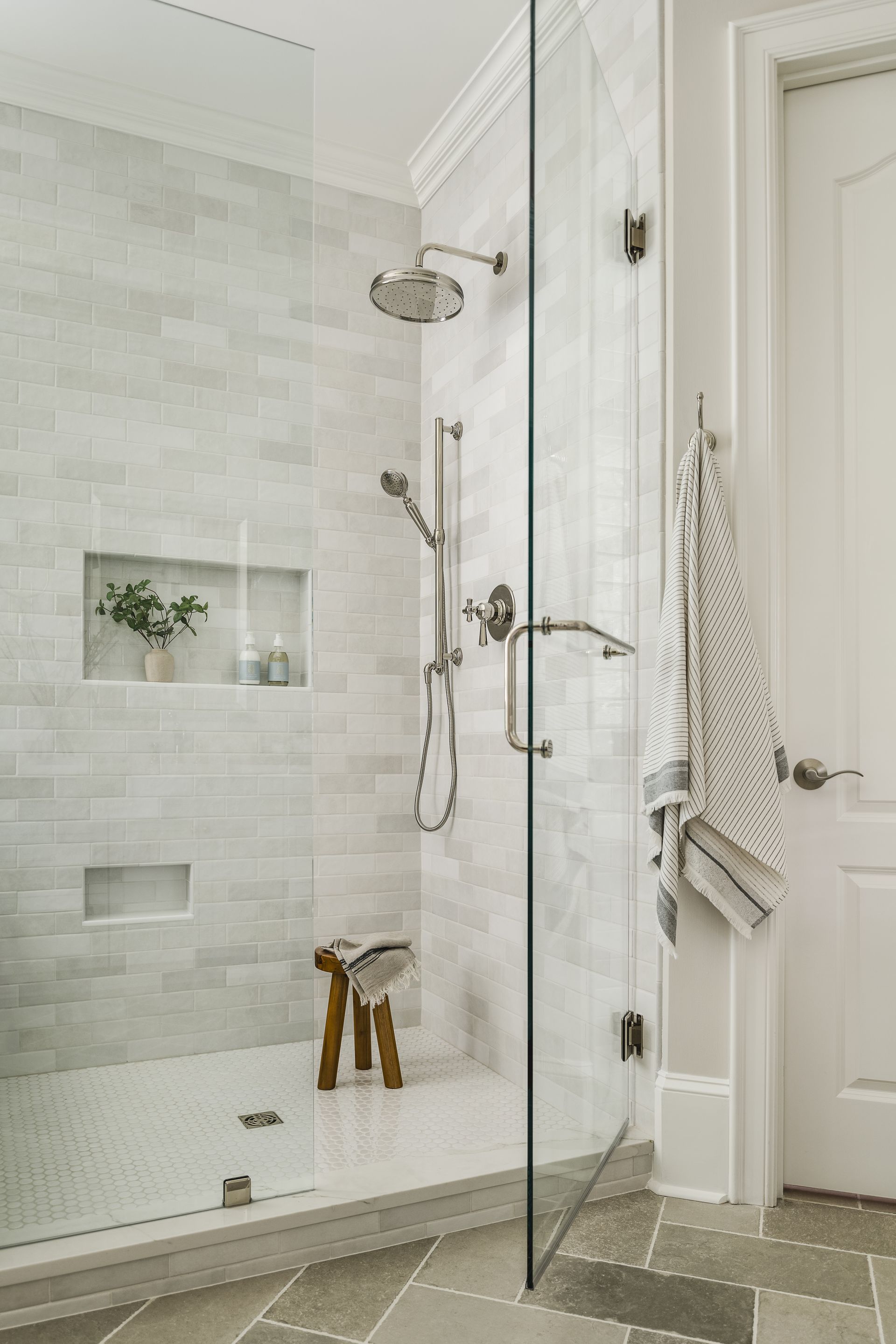 A bathroom with a walk in shower with a glass door.