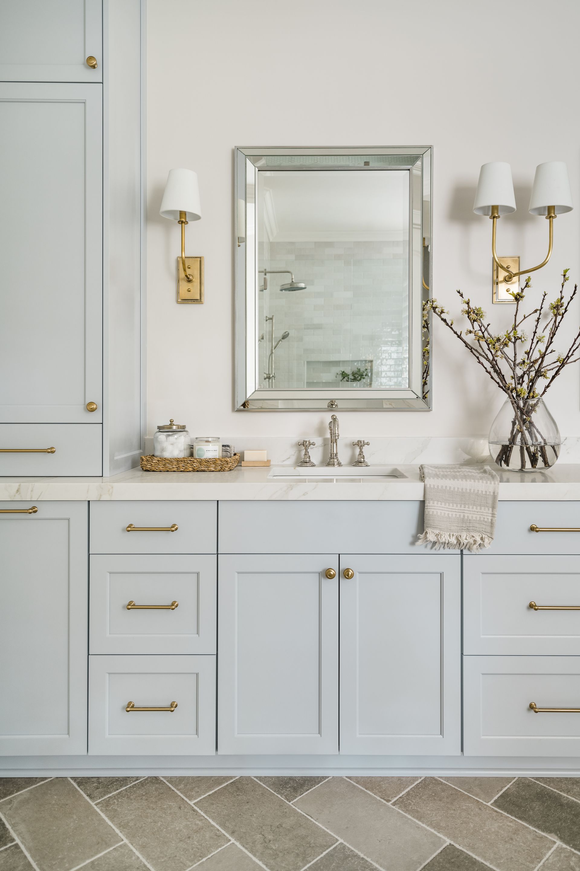 A bathroom with a sink , mirror and cabinets.