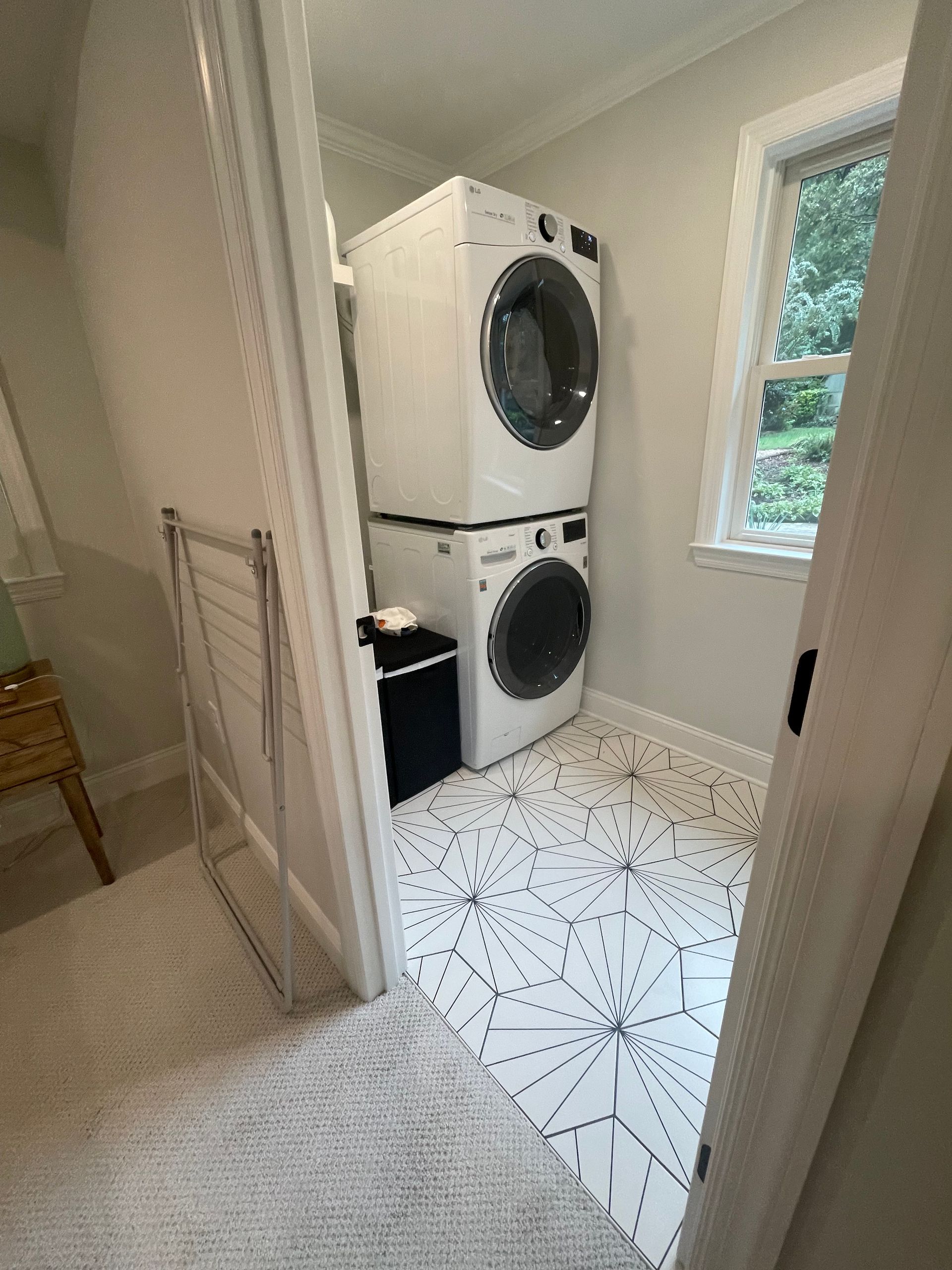 A laundry room with a washer and dryer stacked on top of each other.