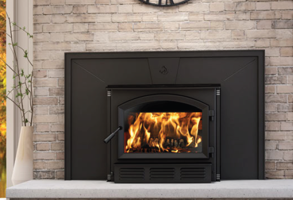 Modern black fireplace with a burning fire set into a light stone wall